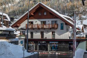 ein großes Gebäude mit Balkon im Schnee in der Unterkunft Lutonia Appartements Sölden in Sölden