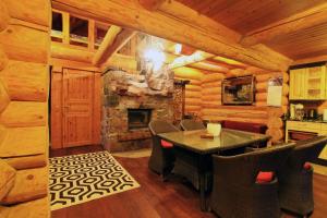 a dining room with a table and a fireplace at Excellent log house with a sauna in Lahemaa! in Hara