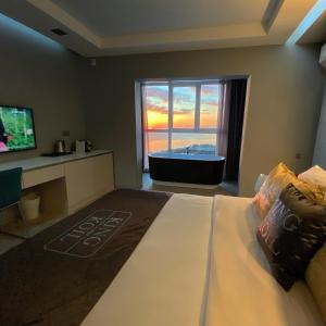 a bedroom with a large bed with a tub and a television at Residence Sky in Sochi