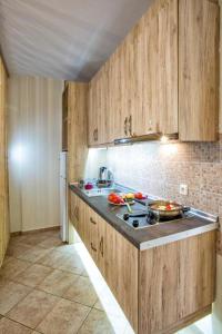 cocina con armarios de madera y horno con fogones en Golden Suites en Ofrínion