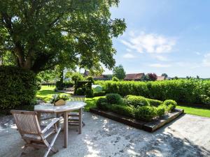 um jardim com mesa, cadeiras e arbustos em Cushy Apartment with Private Terrace Heating em Maldegem