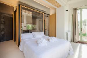 una camera da letto con un grande letto bianco con asciugamani di Can Moio Turismo de Interior a Montuiri