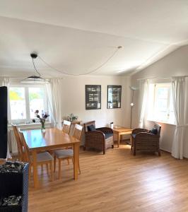 a living room with a wooden table and chairs at Meerblick Apartment in Göhren