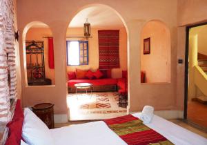 a living room with a red couch in a room at La Maison Du Vent in Essaouira