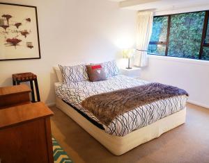 - une chambre avec un lit et une fenêtre dans l'établissement Park to Mountains Apartment, à Arrowtown