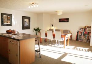 a kitchen and dining room with a table and chairs at Park to Mountains Apartment in Arrowtown