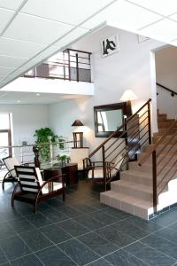 a lobby with stairs and a table and chairs at Adonis Carcassonne in Carcassonne