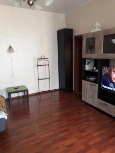 sala de estar con TV y suelo de madera en Apartment on Gatchinskaya, en San Petersburgo
