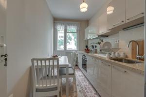 uma cozinha com armários brancos, um lavatório e uma mesa em Beautiful Jewel in Top Center em Sófia