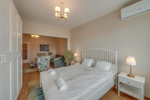 a bedroom with a large white bed and a lamp at Beautiful Jewel in Top Center in Sofia