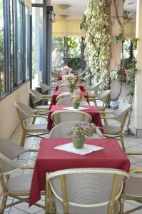 een rij tafels en stoelen met rode tafelkleden bij Hotel Dall'Ara in Villa Marina +37 foto's