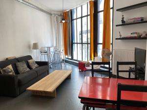 a living room with a couch and a table at Artistic apartment center of Paris in Paris