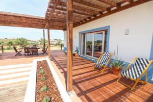 una terraza de madera con 2 sillas y una mesa en Monte das Mós en Ourique