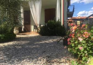a house with a yard with flowers and a porch at Appartamento Sofia in Lazise