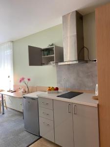a kitchen with white cabinets and a counter top at Dzintars Hotel in Jūrmala