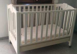 a white crib with a mattress in a room at Appartamento Sofia in Lazise