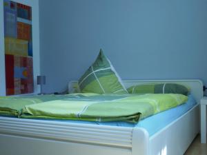 een bed in een kamer met een blauwe muur bij Ferienwohnung Emilia in Münsingen