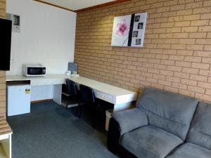 - un bureau avec un bureau et une chaise dans la chambre dans l'établissement Country Home Motor Inn, à Shepparton