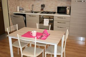 a kitchen with a table with a pink napkin on it at Le Margherite in Cardano al Campo +23 photos