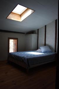 Schlafzimmer mit einem großen Bett und einem Dachfenster in der Unterkunft Montségur ARIEGE grande maison éco-rénovée in Montségur