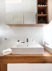 a bathroom with a white sink and a wooden counter at Armi Luxury Apartment in the Heart of the City in Chania Town +28 photos