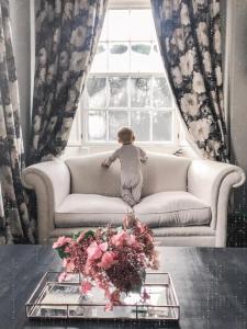 a small child sitting on a couch in a living room at Dovenby Apartment- great base for exploring Lake District in Cockermouth