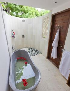 a bathroom with a bath tub with a window at Villa Nusa in Nusa Lembongan