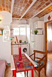 a small kitchen with a table and a refrigerator at Las Golondrinas de la Alhambra in Granada