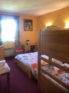 a bedroom with a bunk bed and a desk at Hôtel Restaurant La Manse in Dornecy