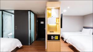 a hotel room with two beds and a elevator at LALA VIANCO BUSINESS Hotel in Busan