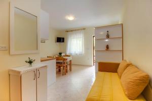 a small living room with a couch and a kitchen at Biserka apartments near the beach and center in Mali Lošinj