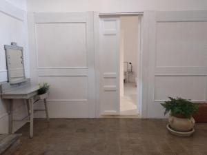 um quarto com paredes brancas, uma secretária e um espelho em La Chiave di Volta em Ragusa