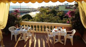 een tafel en stoelen op een patio met uitzicht op de oceaan bij Hotel Italia in Marina di Massa