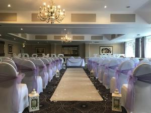 a rows of chairs in a room with a chandelier at Stone House Hotel ‘A Bespoke Hotel’ in Stone