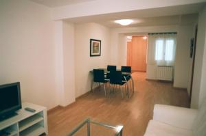 un soggiorno con tavolo da pranzo e sedie di Apartamentos Auhabitat Zaragoza, edificio de apartamentos turísticos a Saragozza