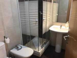 y baño con ducha, aseo y lavamanos. en Apartamentos Auhabitat Zaragoza, edificio de apartamentos turísticos, en Zaragoza