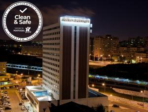 een hoog wit gebouw met een bord erop bij VIP Executive Zurique Hotel in Lissabon