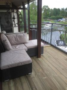 uma varanda com 2 camas e vista para um rio em Waterfront House In The Heart Of St Neots em Saint Neots