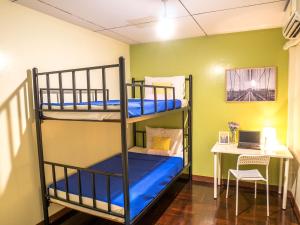 a room with two bunk beds and a desk at Chan Cha La 99 Hostel in Bangkok