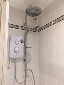 a shower with a shower head in a bathroom at River Courtyard Apartment In The Heart Of Stneots in Saint Neots