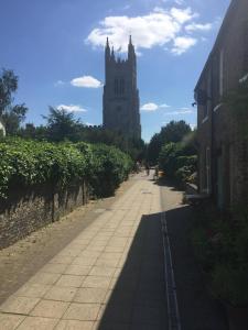 una calle con una torre de reloj y un edificio en River View House St Neots - Navigation Wharf, en Saint Neots