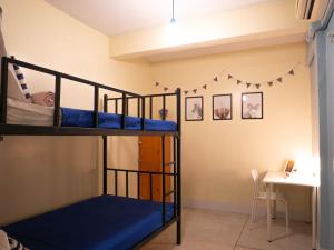Chan Cha La 99 Hostel في بانكوك: غرفة نوم مع سريرين بطابقين ومكتب