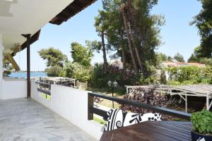 a balcony with a table and a view of the water at Haus Platanos Apartments & Bungalows by the Sea in Vourvourou