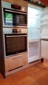 eine Küche mit 2 Backöfen und einem offenen Kühlschrank in der Unterkunft Jagdhaus Malzhagen in Nümbrecht