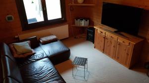 ein Wohnzimmer mit einem Sofa und einem Flachbild-TV in der Unterkunft Jagdhaus Malzhagen in Nümbrecht
