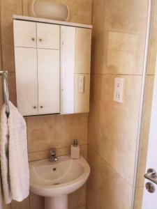 a small bathroom with a sink and a cabinet at Adalena Court in Paralimni