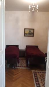 クヴァレリにあるGuest House Gzirishviliのベッド2台が備わる客室で、壁には絵画が飾られています。