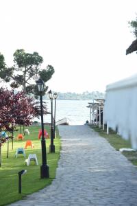 a stone walkway next to a body of water at Haus Platanos Apartments & Bungalows by the Sea in Vourvourou