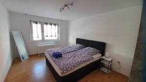 a bedroom with a bed with purple sheets and a window at Ferienwohnung Biewer in Trier