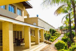 um edifício com uma mesa e cadeiras e palmeiras em Naledzi Hotel & Conference centre em Thohoyandou